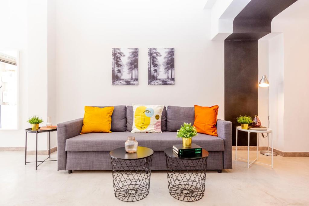a living room with a couch and two tables at Psirri Lofts in Athens