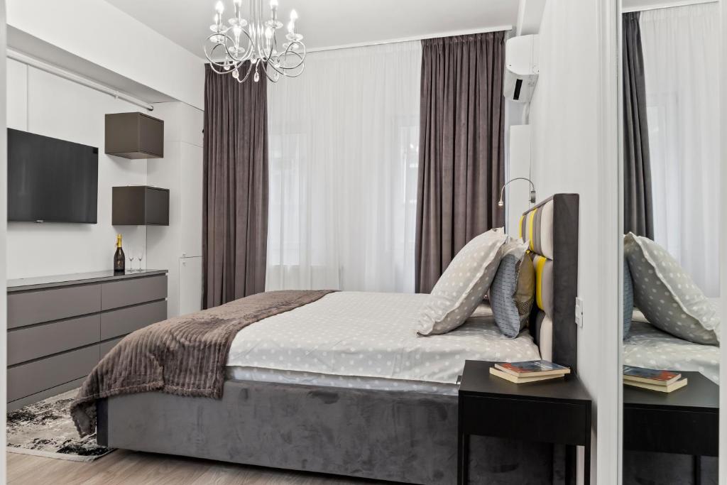 1 dormitorio con cama y lámpara de araña en Brand New Studio - Old Town, en Bucarest