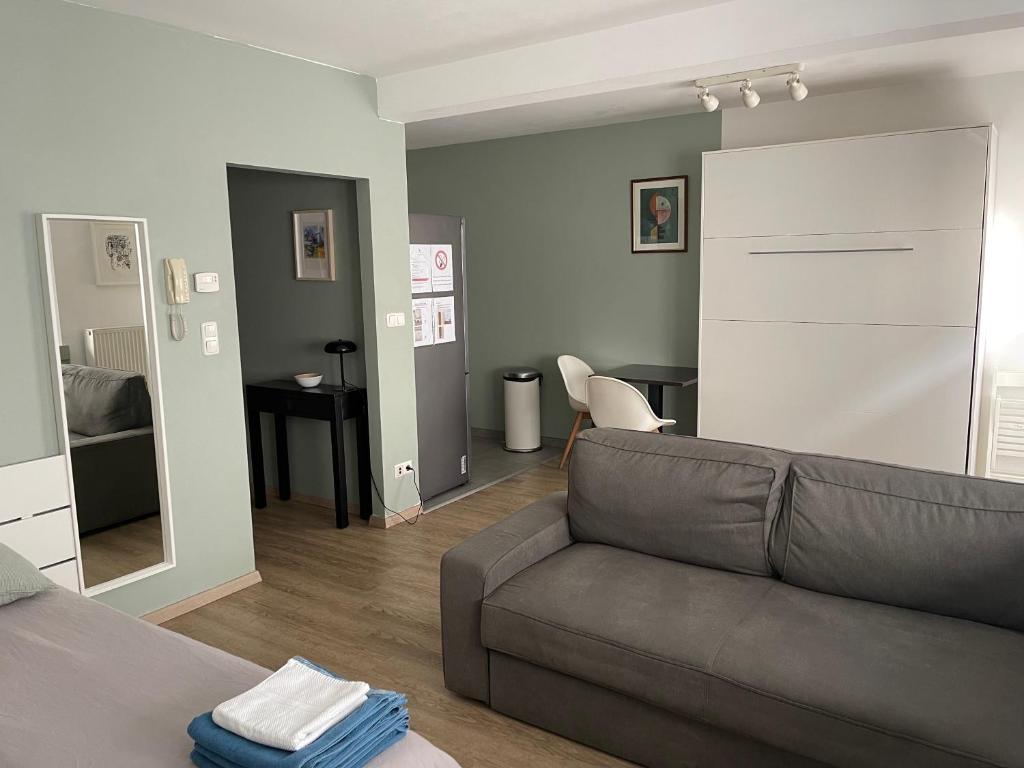 a living room with a couch and a mirror at Studio close from train station and shops in Luxembourg
