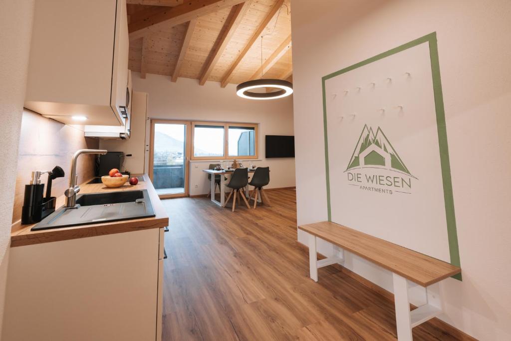 a kitchen and living room with a sign on the wall at Die Wiesen Apartments in Innsbruck
