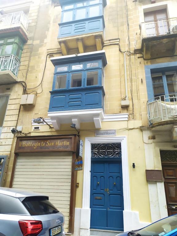 un edificio con una puerta azul y un garaje en Casa Manduca Delicata, en La Valeta