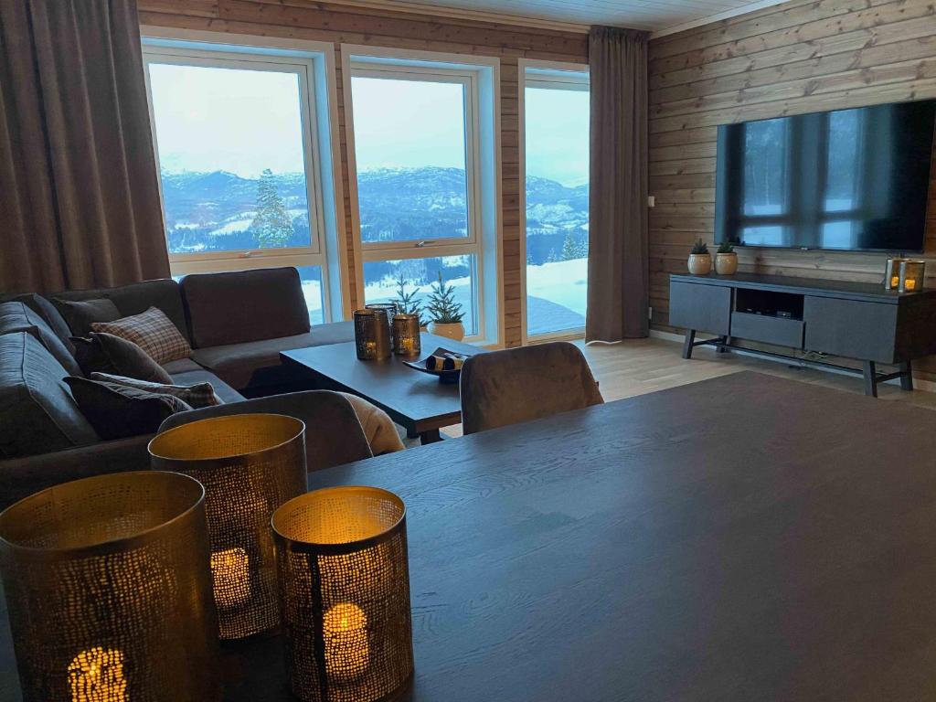 sala de estar con mesa con sillas y TV en New modern apartment with great view - ski in & out, en Skulestadmo