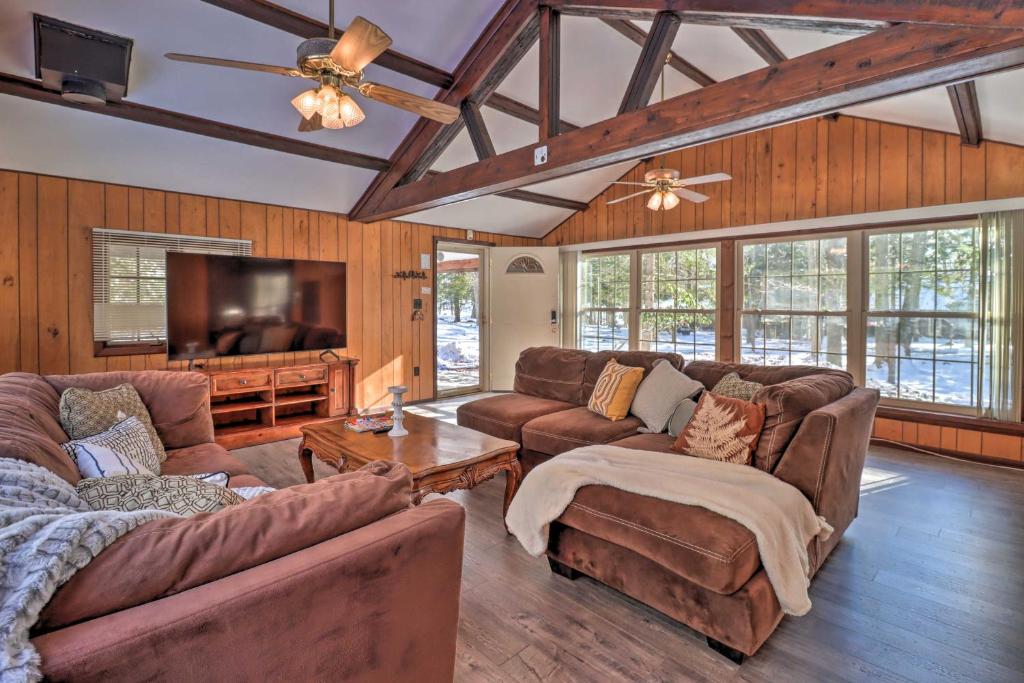 a living room with couches and a flat screen tv at Rustic Lake Harmony Home with Fire Pit and Hot Tub! in Lake Harmony