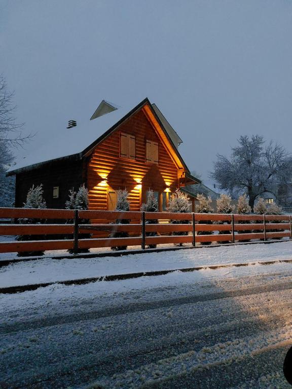 a wooden barn with lights on it in the snow at Zara Chalet in Kolašin