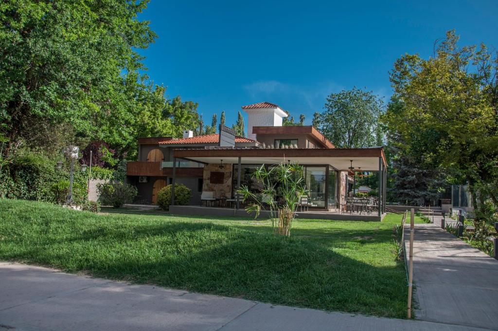 una casa en un césped verde con un árbol en Terra Campo Posada en Chacras de Coria