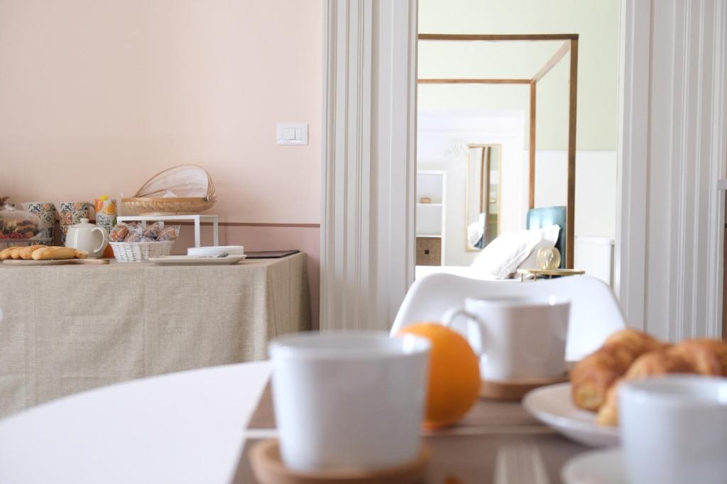 a table with a plate of pastries and a mirror at Toscano Palace Luxury Rooms Catania in Catania