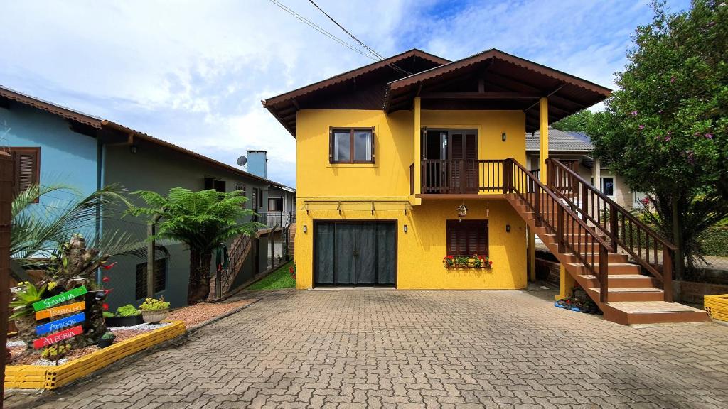 a yellow house with a staircase in a driveway at Casa Palace Canela in Canela
