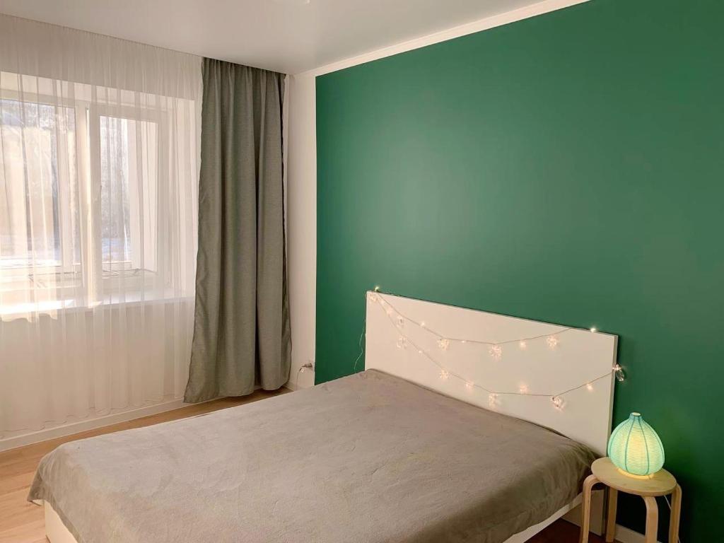 ein Schlafzimmer mit einem Bett mit einer grünen Wand in der Unterkunft Olive Home in Oral
