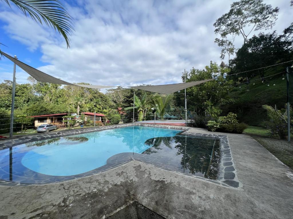 ein Schwimmbad in einem Garten mit Baldachin darüber in der Unterkunft Bamboo River House and Hotel in Dominical