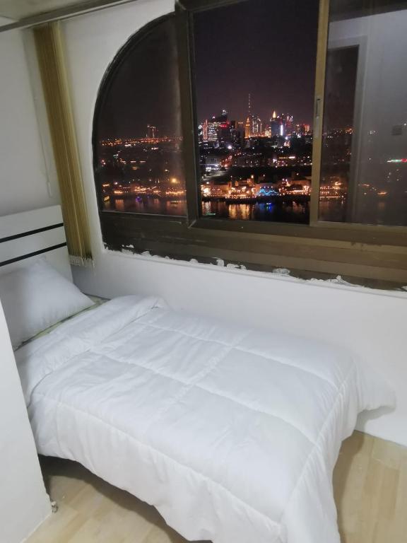 un letto in una camera con una grande finestra di Cloud9 hostel a Dubai