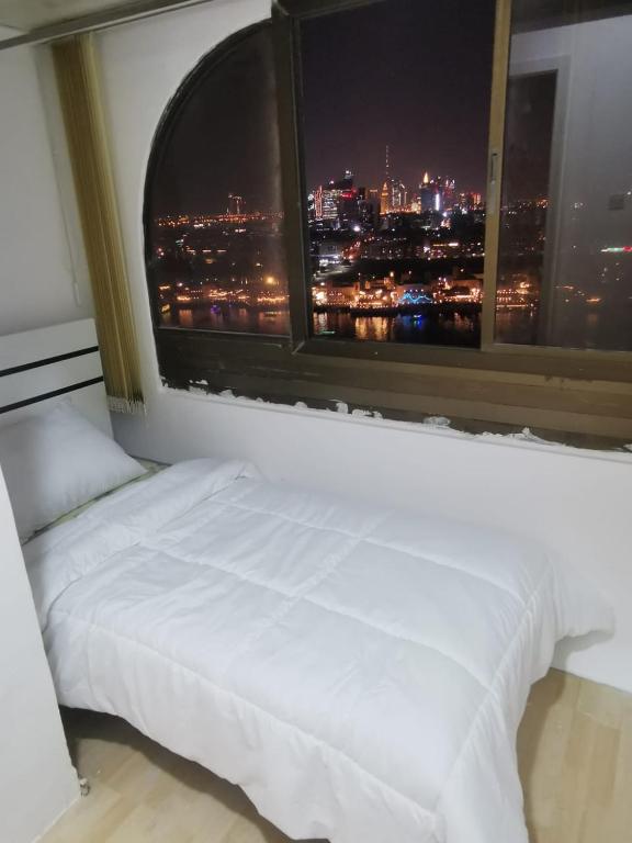 a bed in a room with a large window at Cloud9 hostel in Dubai