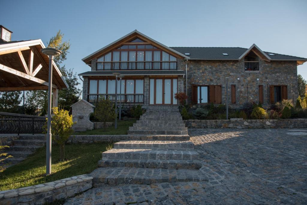 a house with a stone pathway leading up to it at Luxury Villa Saint Nikolas in Voskopojë