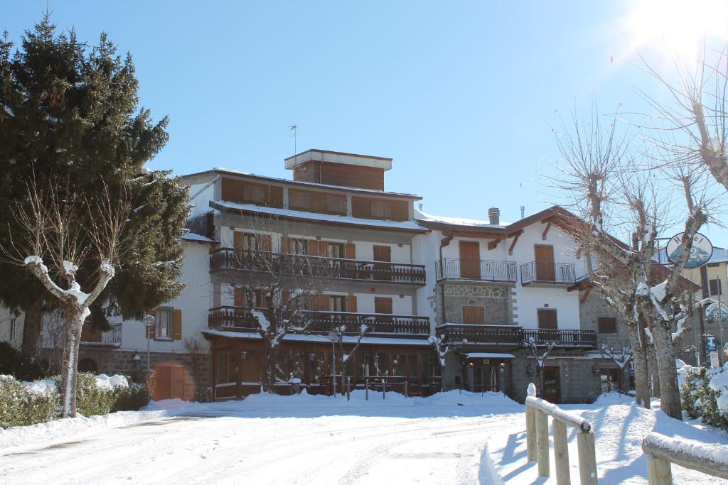 un grand bâtiment avec de la neige devant lui dans l'établissement Albergo Ristorante K2, à Abetone