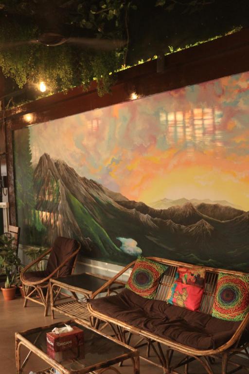 a large painting on the wall with two chairs in front at Forrest Hostels in Mumbai