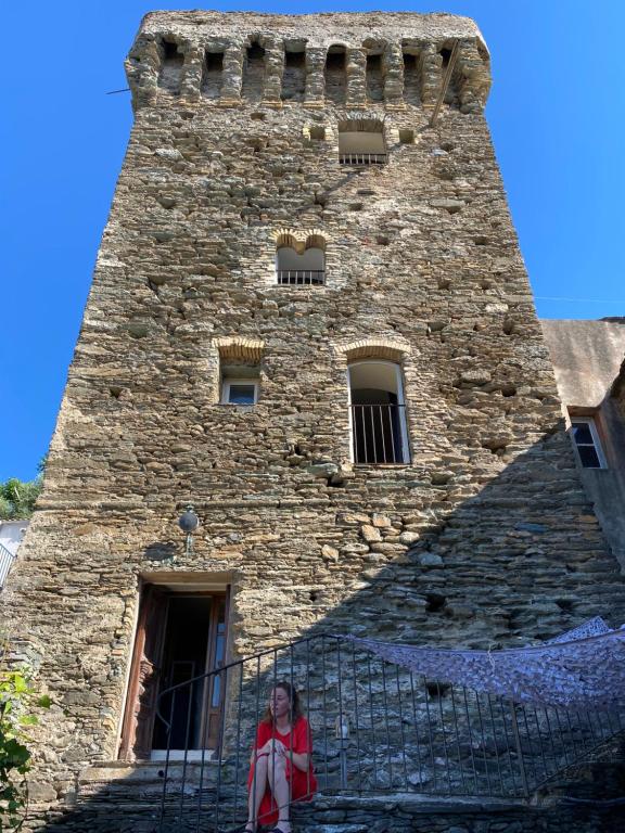 uma mulher em frente a uma torre alta em Torra di Ciocce em Pino