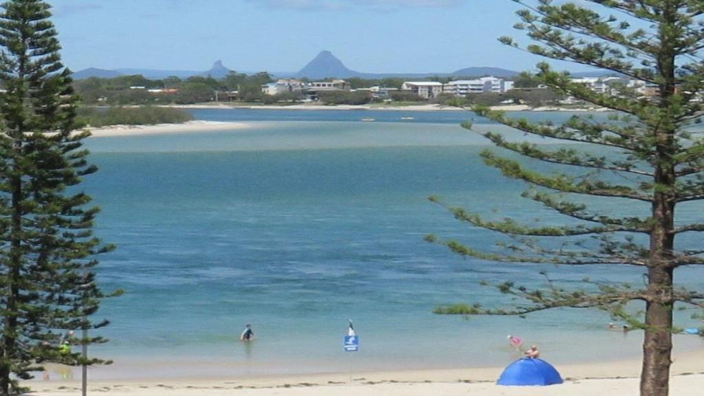 een uitzicht op een strand met mensen in het water bij Kookaburra Court Unit 3 Bulcock Beach QLD in Caloundra