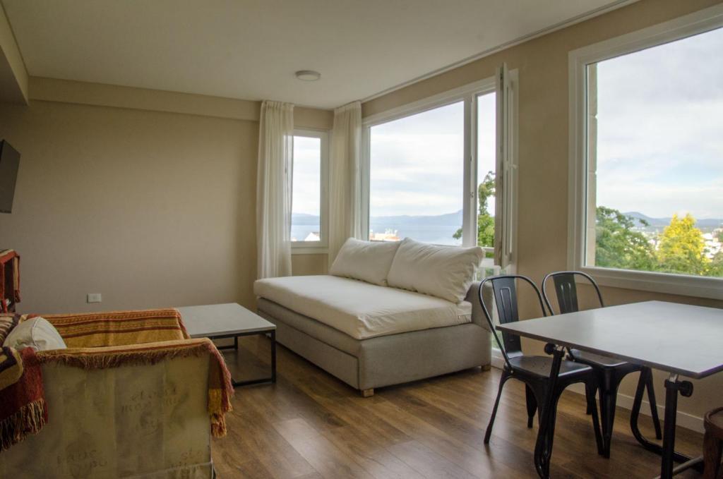 uma sala de estar com um sofá e uma mesa em Departamento con vista em San Carlos de Bariloche