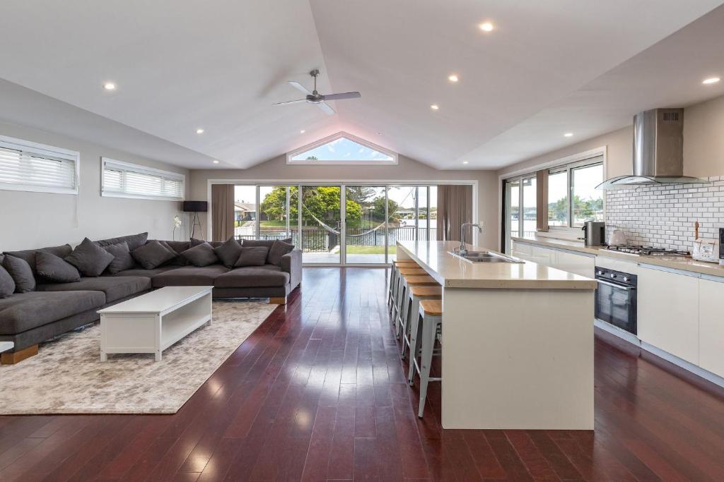 a kitchen and living room with a couch and a table at King George Parade in Forster
