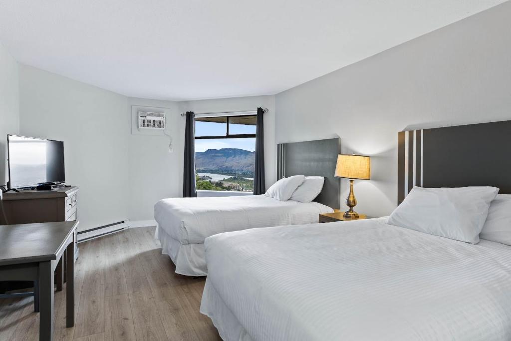 a hotel room with two beds and a window at The Vista Inn in Kamloops