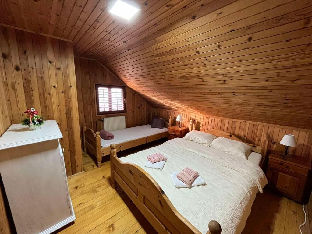 ein Schlafzimmer mit einem Bett in einer Holzhütte in der Unterkunft Brvnara Nenadić in Užice