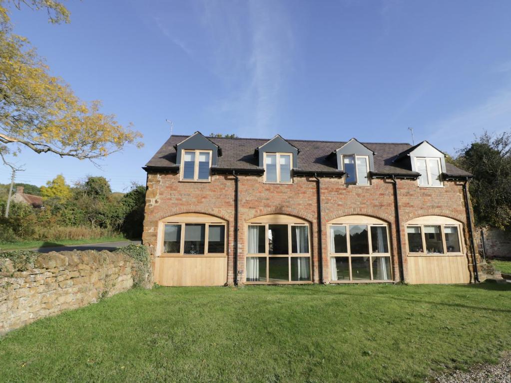 a large brick house with windows on a yard at The Granary in Southam