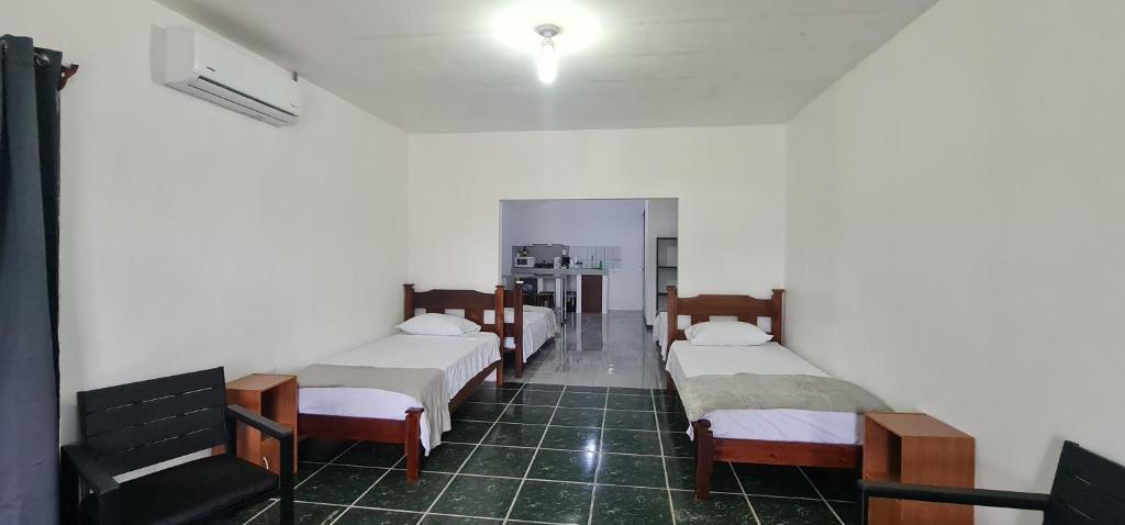 una habitación con una fila de camas. en Sleep&Go! Family room - Cabina empresarial en Siquirres en Siquirres