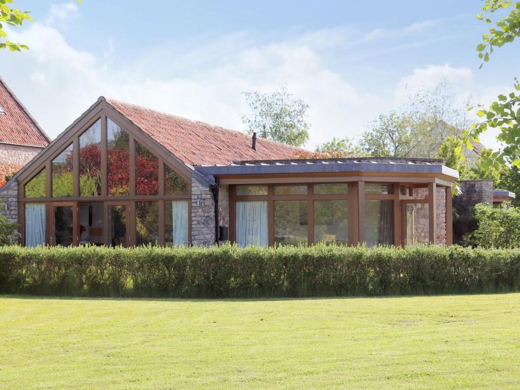 a house with a conservatory on top of a yard at Mow Barton in Wells