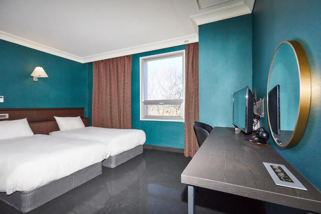 Postel nebo postele na pokoji v ubytování Kolon Hotel