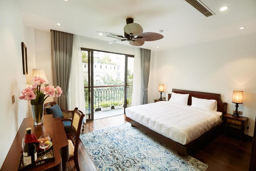 una camera con letto, scrivania e letto Sidx Sidx Sidx di Camellia Residence Hanoi a Hanoi