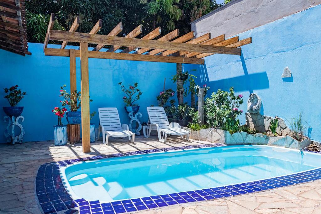 uma piscina com uma pérgola de madeira e cadeiras em Casa c ótima localização piscina e WiFi, Cuiabá em Cuiabá