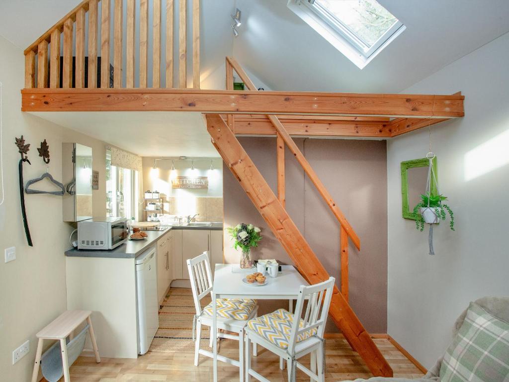 uma cozinha de conversão loft e uma sala de jantar com uma escadaria em Aremo Garden House em Torquay