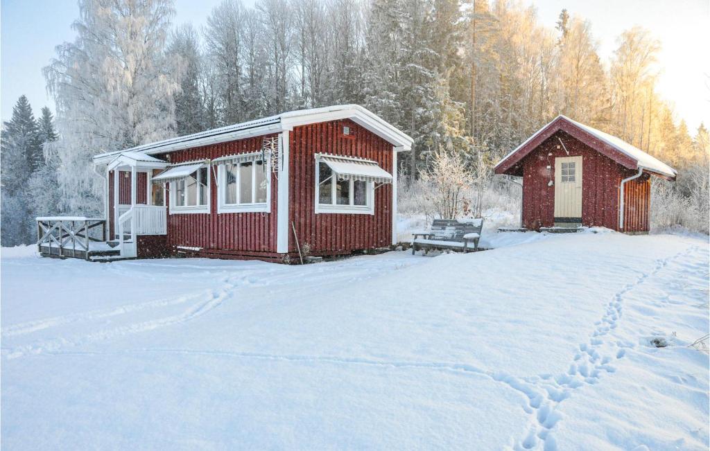 a red cabin with snow on the ground in front at 2 Bedroom Amazing Home In Rottneros in Rottneros