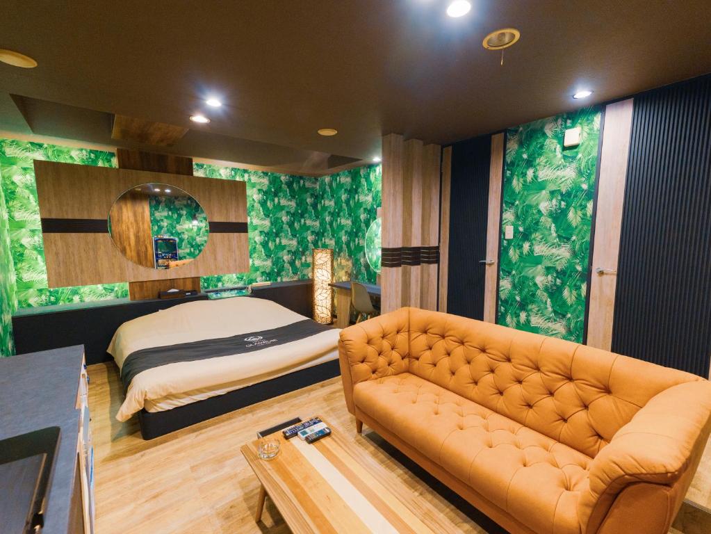ein Wohnzimmer mit einem Sofa und einem Bett in der Unterkunft GLAMROSE -Adult Only- in Gotemba