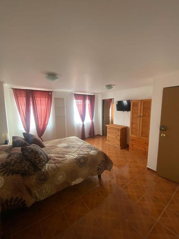 1 dormitorio con 1 cama y cortinas rojas en Nada, en Coquimbo