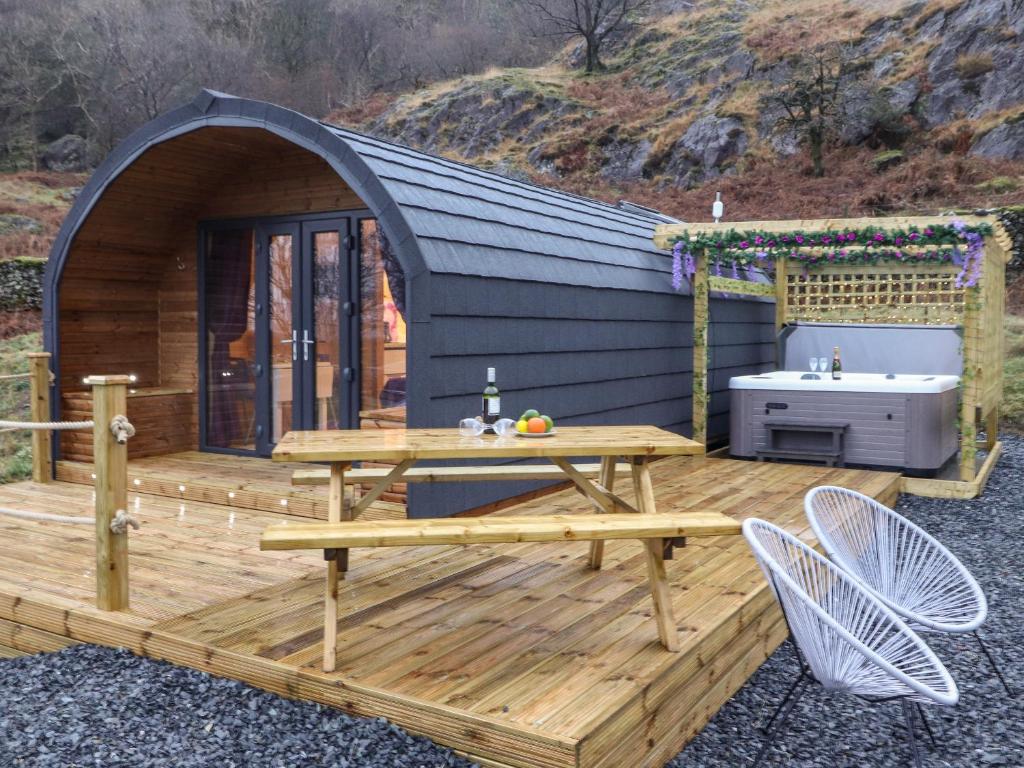 a wooden deck with a picnic table and a tub at Lovies Place - Crossgate Luxury Glamping in Penrith