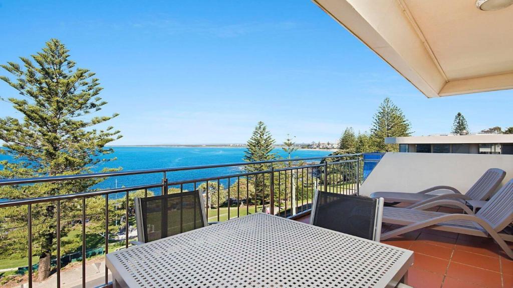 einen Balkon mit einem Tisch, Stühlen und Meerblick in der Unterkunft Wickham Point Unit 5 Kings Beach QLD in Caloundra