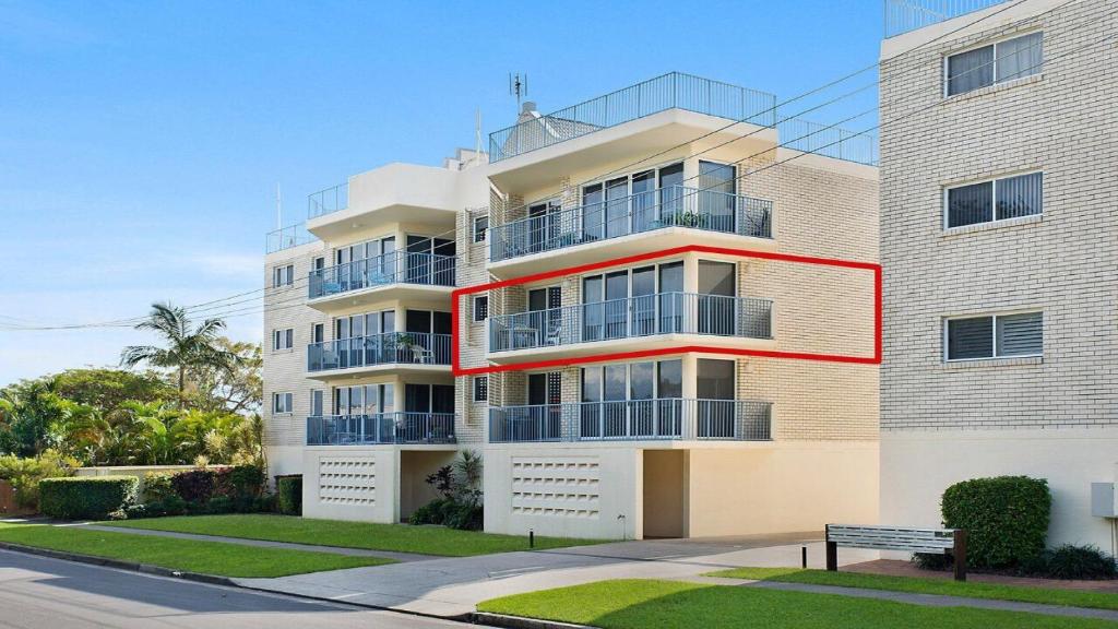 Windbourne unit 4 Golden Beach QLD في Golden Beach: مبنى ابيض طويل وعليه خط احمر