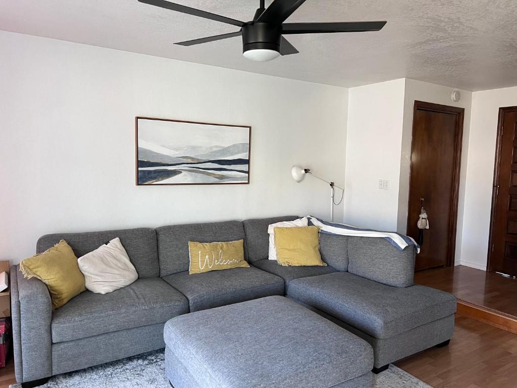 sala de estar con sofá gris y ventilador de techo en Hathaway a family home, en Corvallis