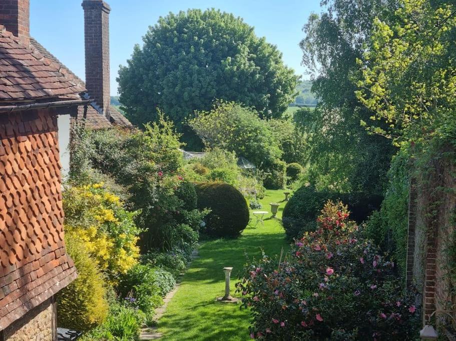 a garden with bushes and trees and a brick building at Monk House - Historic Foundation Invites guests in Petworth