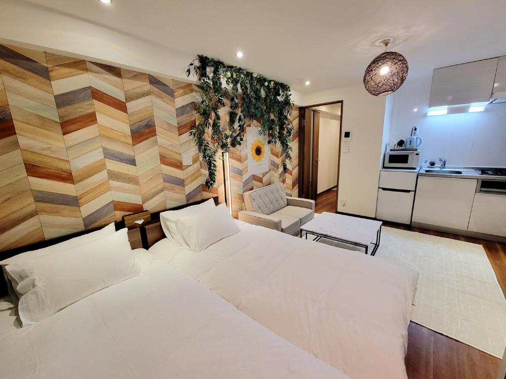 een slaapkamer met een groot wit bed en een keuken bij 新大久保ヴィラヨシダ in Tokyo