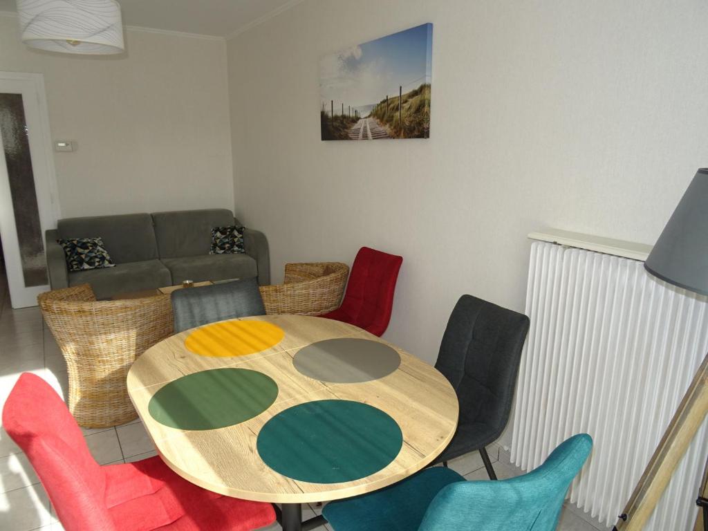une salle à manger avec une table et des chaises colorées dans l'établissement Appartement T2 avec loggia et parking, proche plage et commerces aux Sables d'Olonne - FR-1-92-912, à Les Sables-dʼOlonne