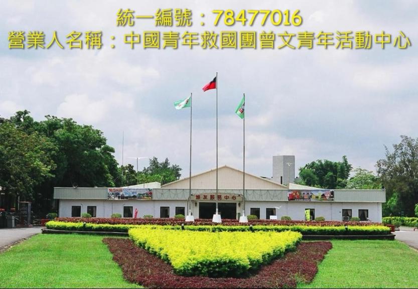 um edifício com três bandeiras à sua frente em Tsengwen Youth Activity Center em Nanxi