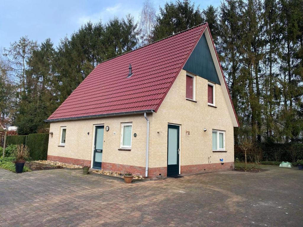 een groot wit gebouw met een rood dak bij Scenic holiday home in Schoonloo with garden in Schoonloo