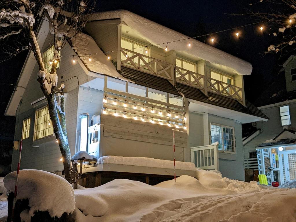 a house with a porch with lights on it at モンブラン白馬ファミリア バケーションハウス in Hakuba