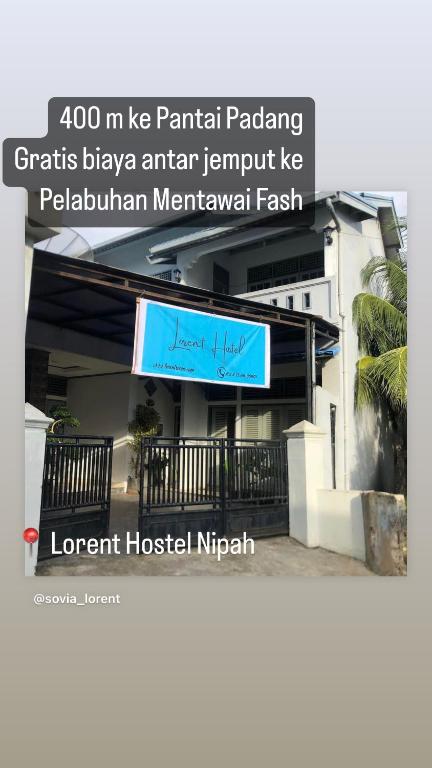 a sign for a hotel in front of a building at Lorent Hostel Near Padang Beach in Padang
