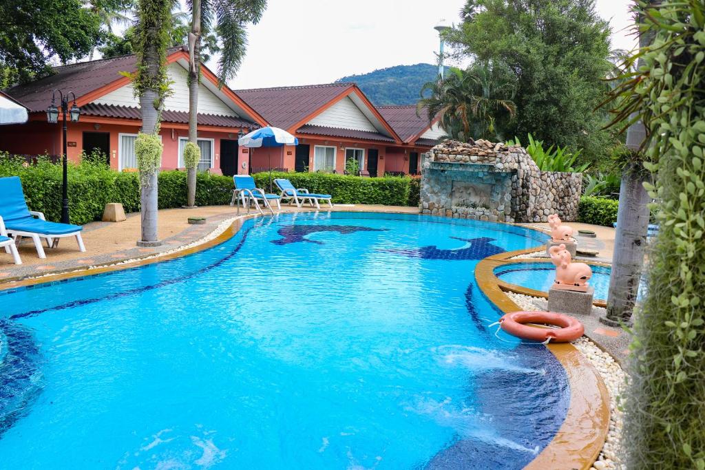 a swimming pool with a child in the middle of it at Andaman Seaside Resort - SHA Extra Plus in Bang Tao Beach