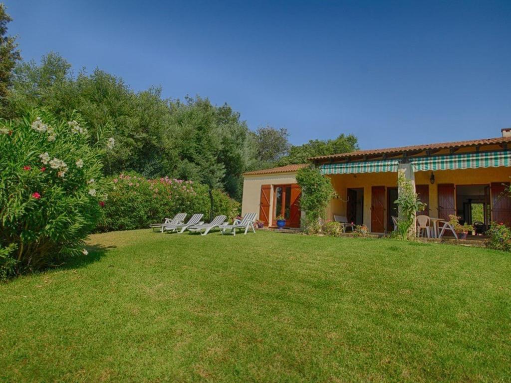 un cortile con sedie a sdraio e una casa di Maison Casaglione-Tiuccia, 4 pièces, 6 personnes - FR-1-61-510 a Casaglione