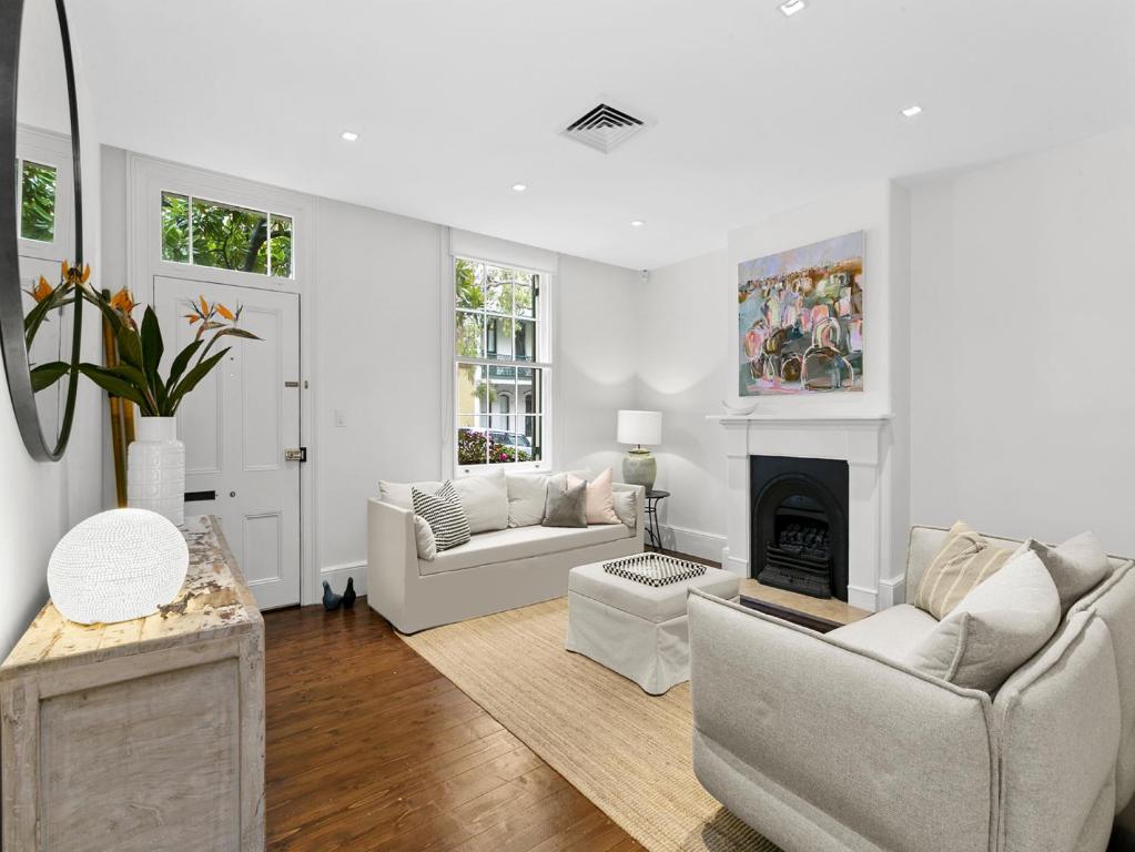 a living room with white furniture and a fireplace at WIND82D - Windmill at Dawes in Sydney