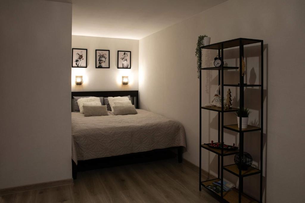 a bedroom with a bed and two pictures on the wall at Studio apartamenti in Alūksne