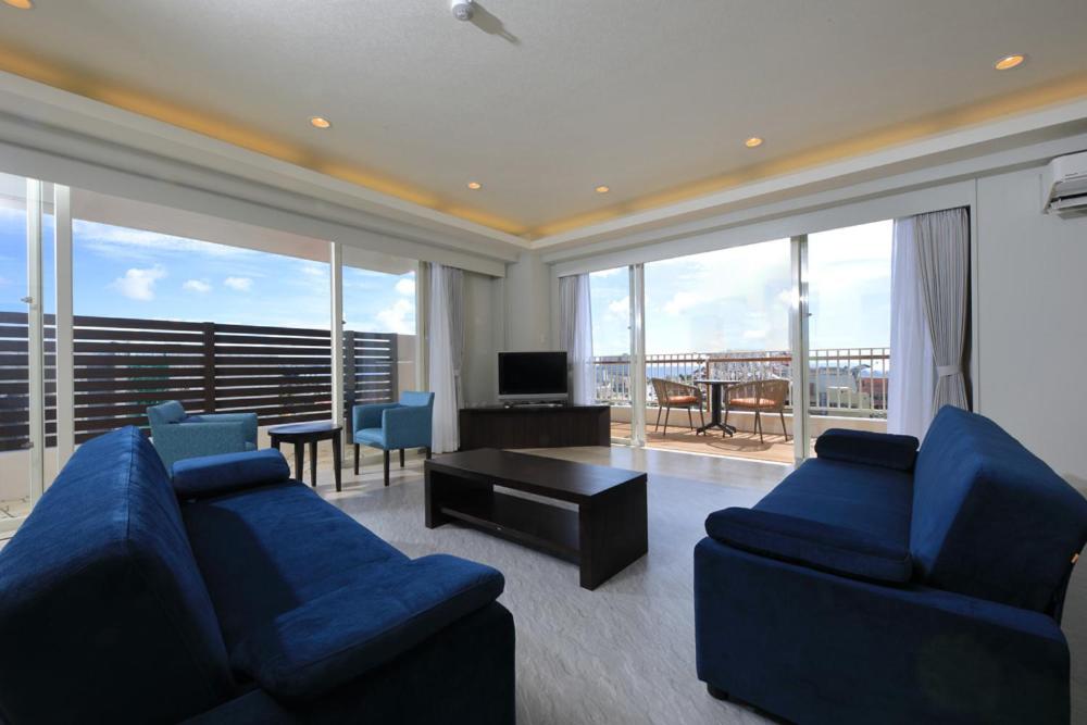 a large living room with blue couches and a television at Terrace Garden Mihama Resort by Coldio Premium in Chatan